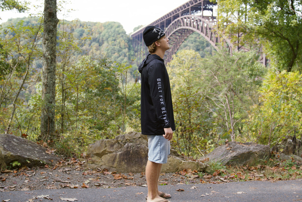 Side view of the black Explorer sun hoodie showing the BUILT FOR BEYOND sleeve print