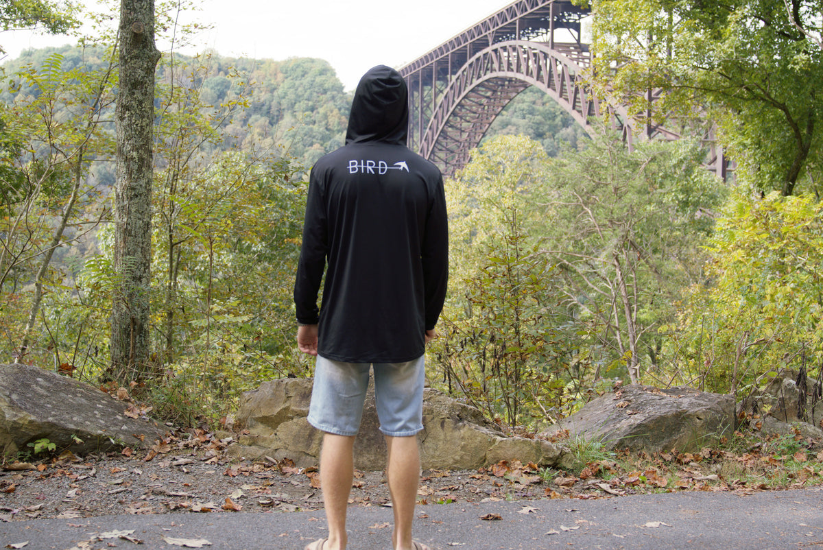 Back of the black Explorer sun hoodie worn with the hood up at the New River Gorge