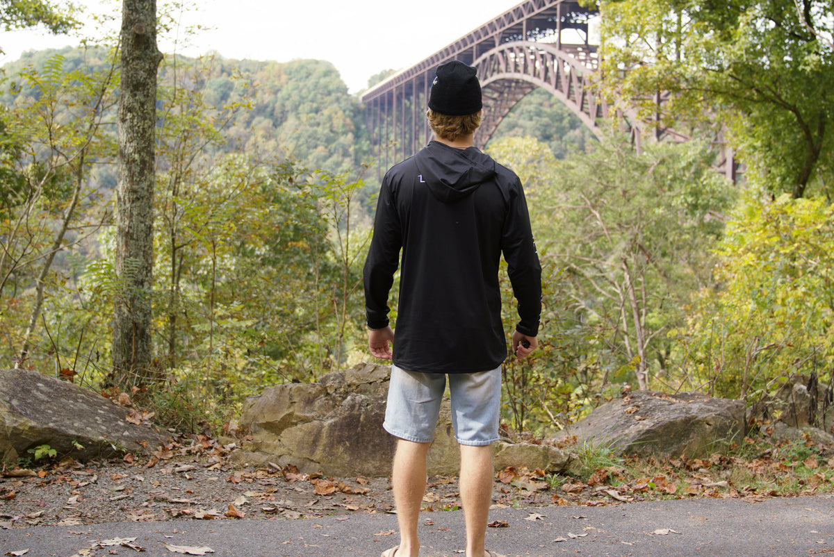 Back of the black Explorer sun hoodie with the hood down showing body drape