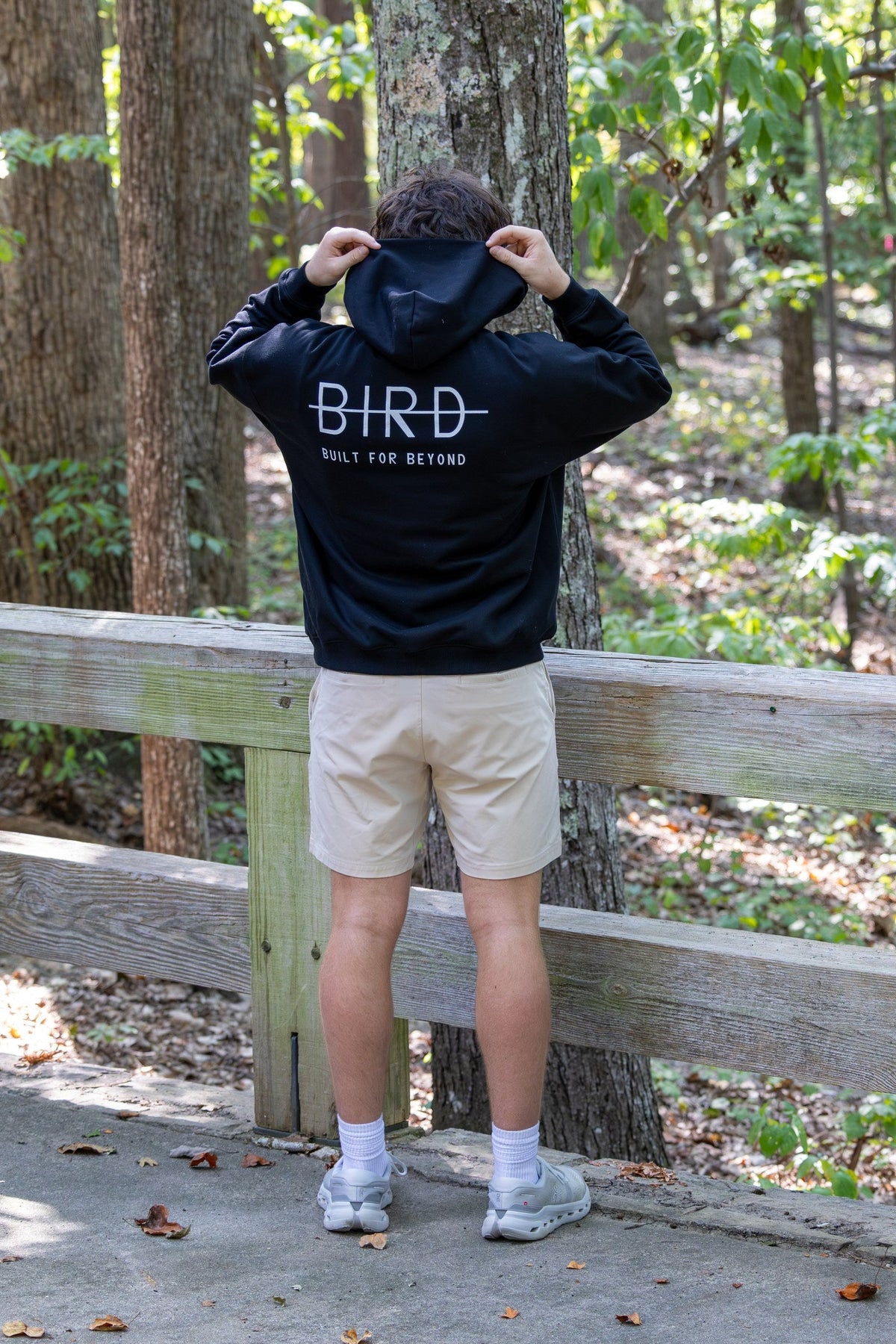 Back of the BIRD Campsite Heavyweight Hoodie, pulling the hood on