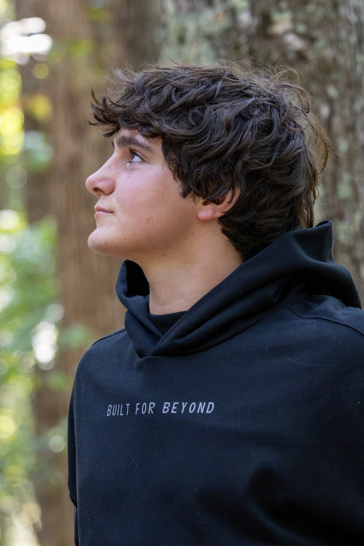 Close-up of the BUILT FOR BEYOND chest print on the black Campsite Heavyweight Hoodie